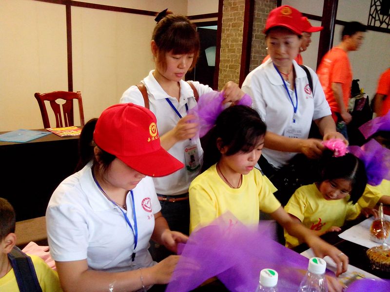 11、联欢现场，义工们为女孩子扎花，并为女孩子们戴在头上.jpg