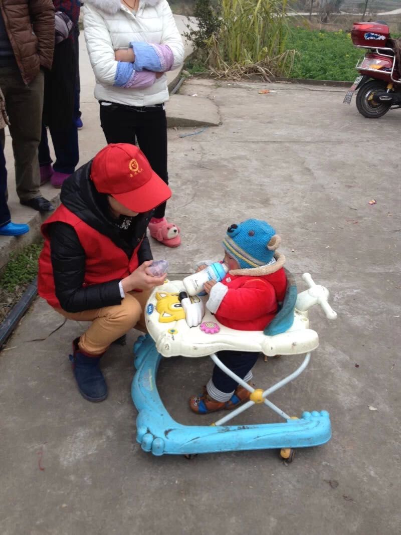岳池义工在给孩子喂奶粉.jpg
